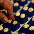 A woman picks a gold earring at a jewellery shop in the old quarters of Delhi, India